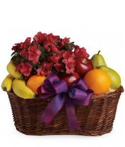 Fresh fruit and flowers arranged together in a gift basket