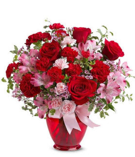 A beautiful red vase filled with red roses and carnations ready for Valentines day delivery.